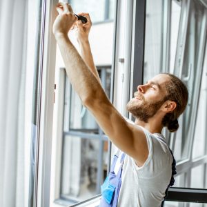 Workman adjusting window frames at home